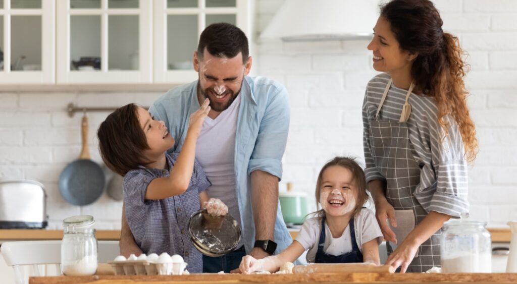 A family with young children baking together.