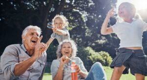 Grandparents blowing bubbles with their grandchildren.