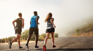 Three people running outdoors.