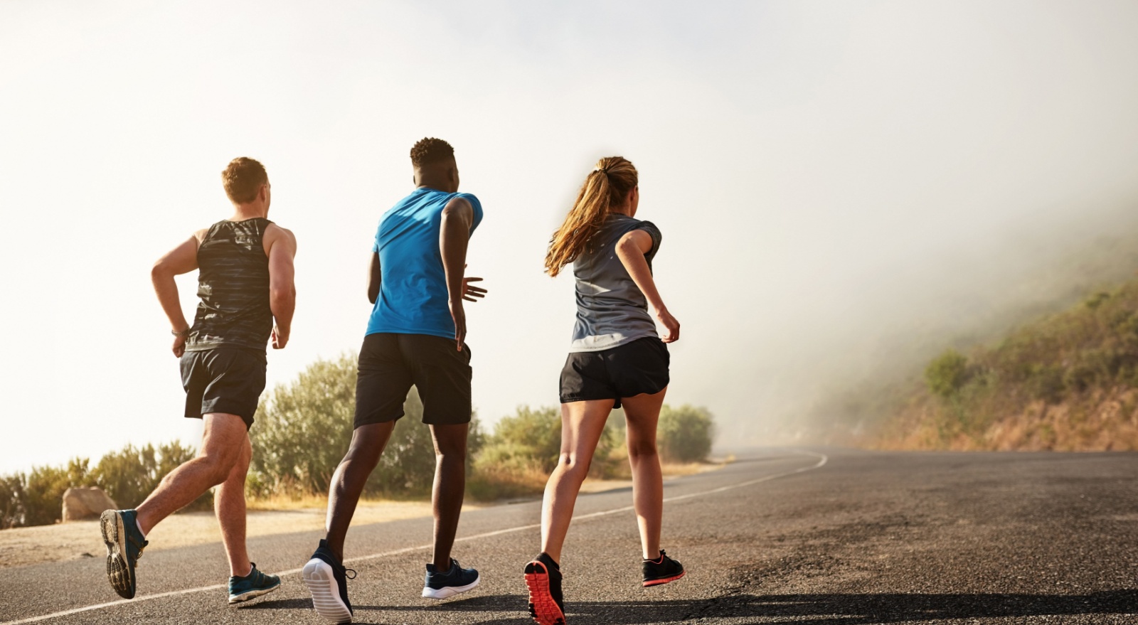 Three people running outdoors.