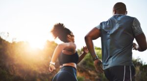 A couple running through a park.