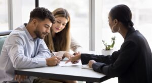 A young couple talking to a mortgage broker.