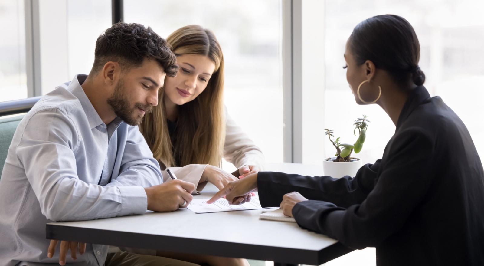 A young couple talking to a mortgage broker.