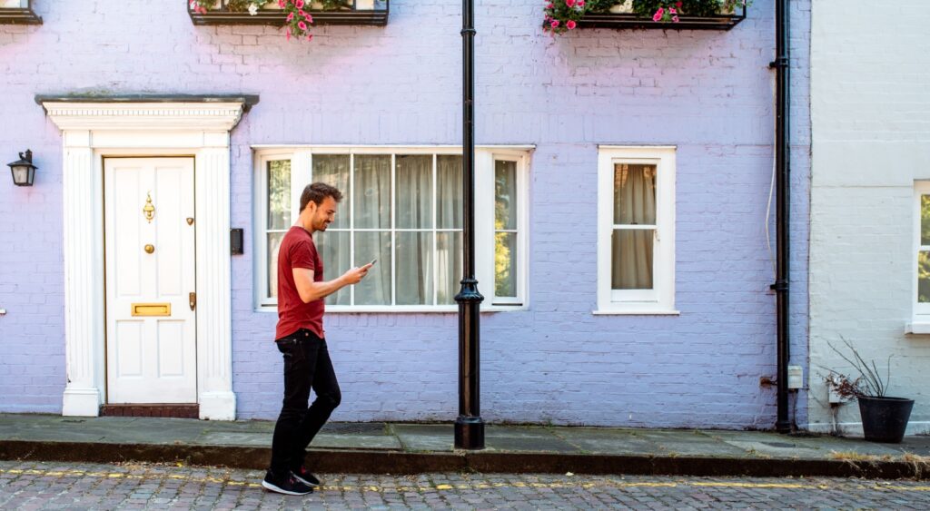 A man walking past the front door of a house.