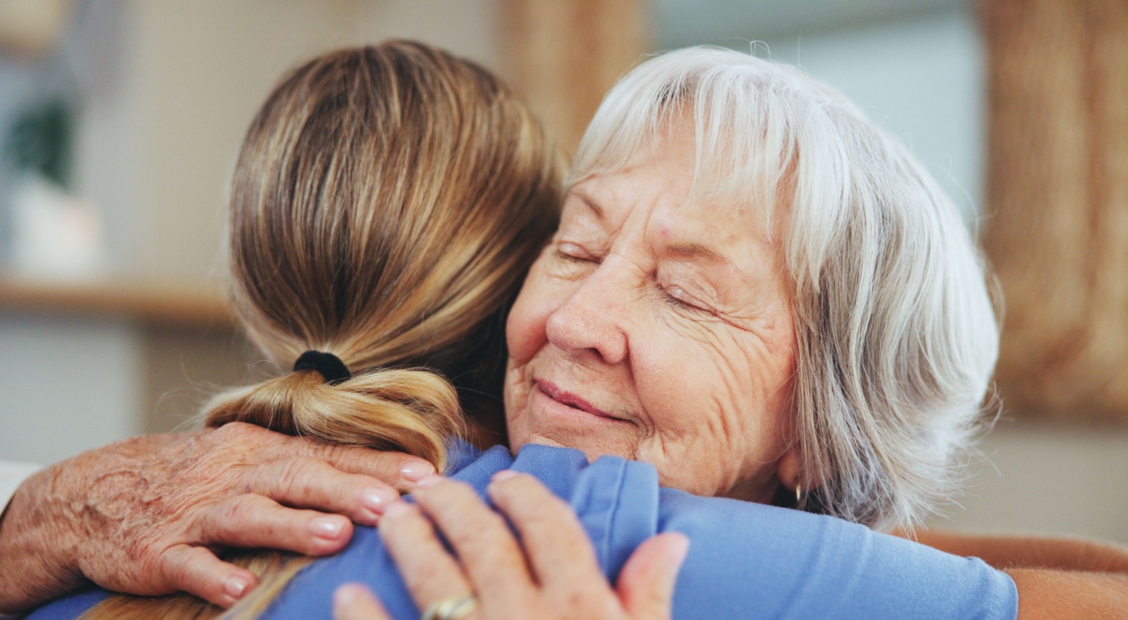 A senior woman hugging a caregiver.