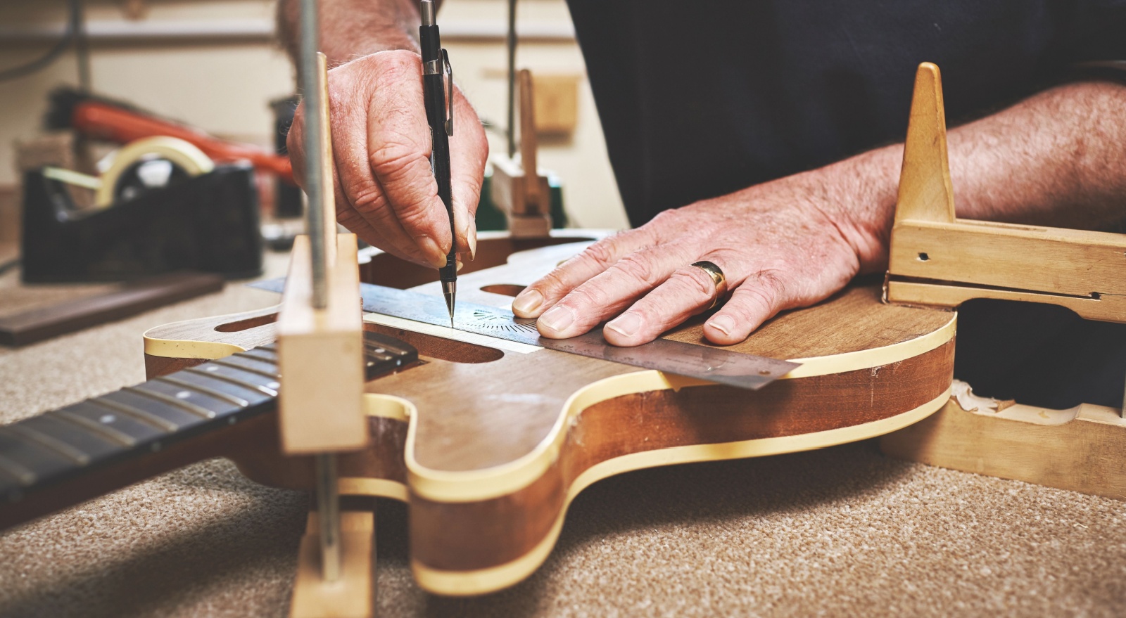 A man fixing a guitar in a workshop.
