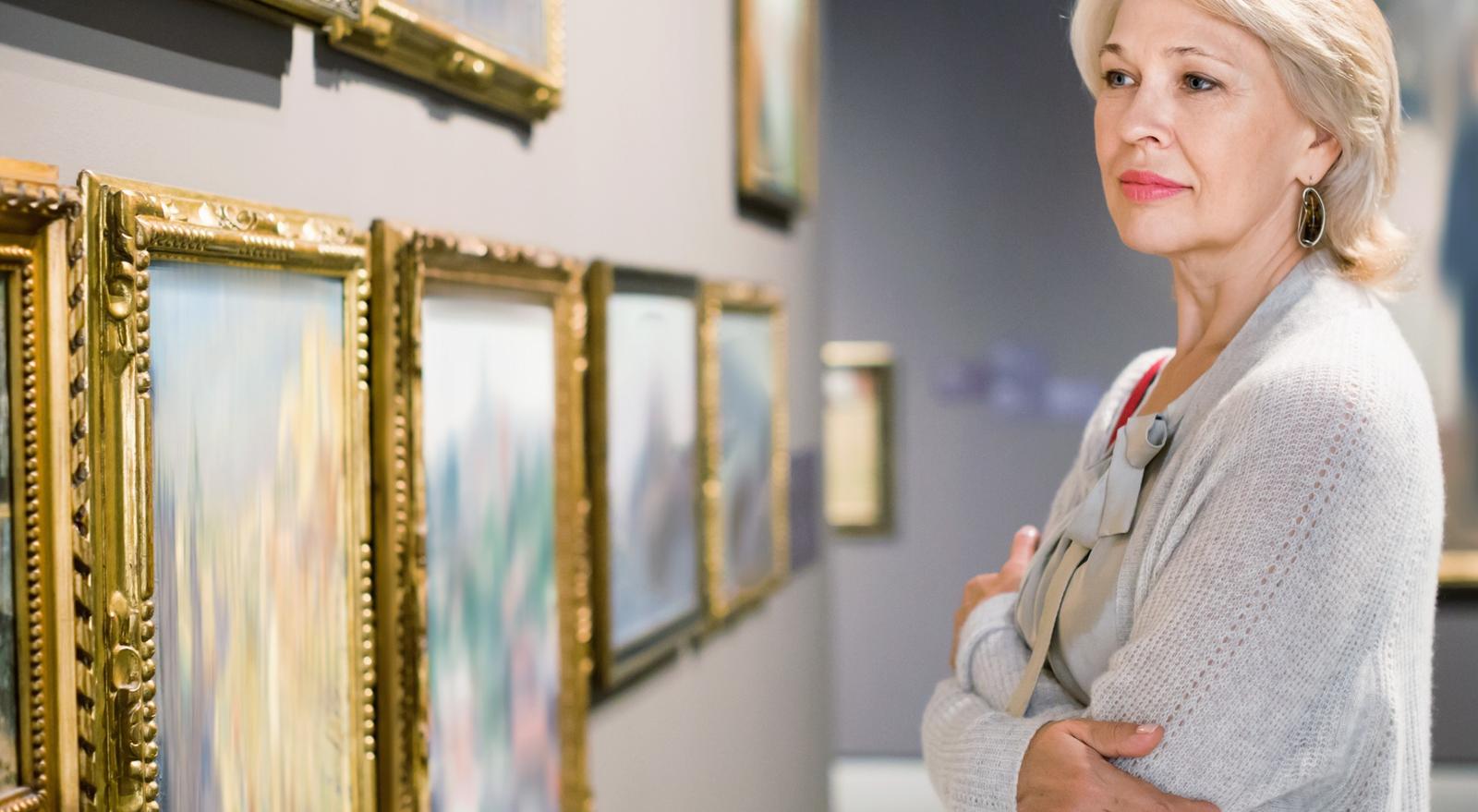 A woman looking at art in a gallery.