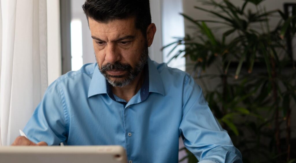 A man looking at a tablet screen.