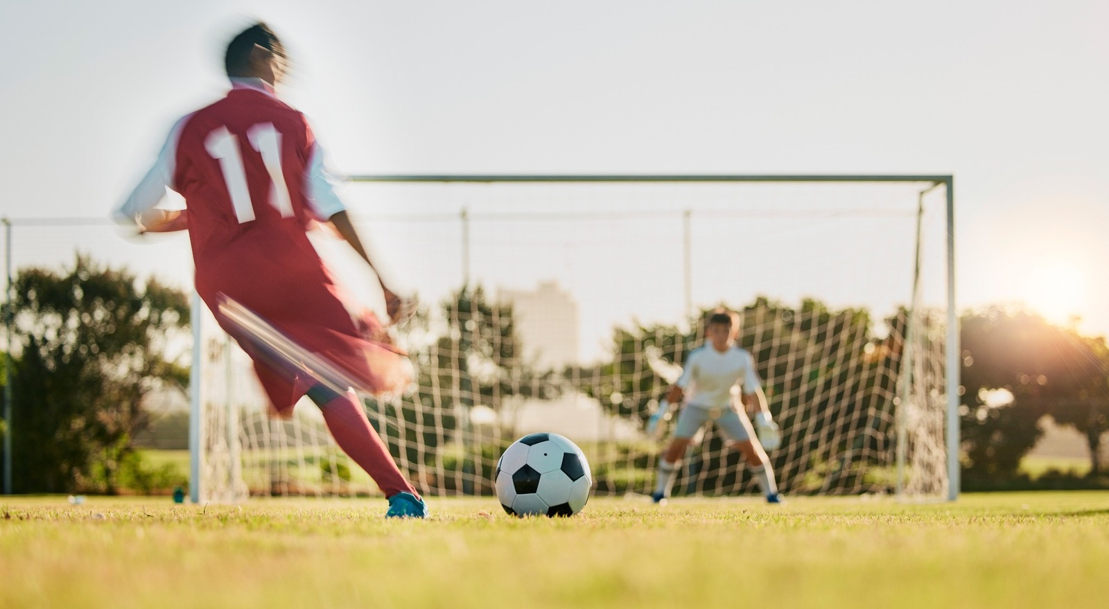 A footballer taking a shot at a goal.