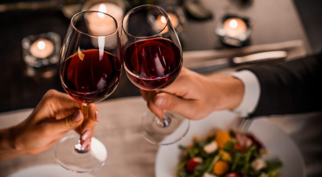 A couple toasting with wine glasses.