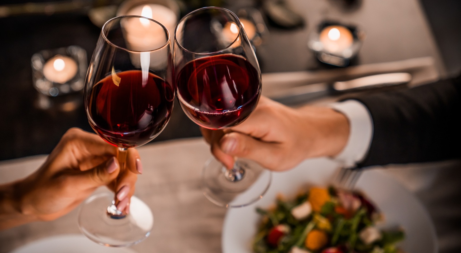 A couple toasting with wine glasses.