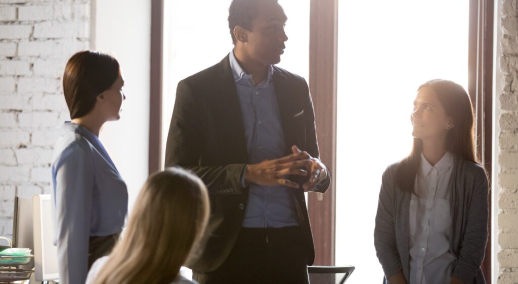 A business owner speaking with his employees.