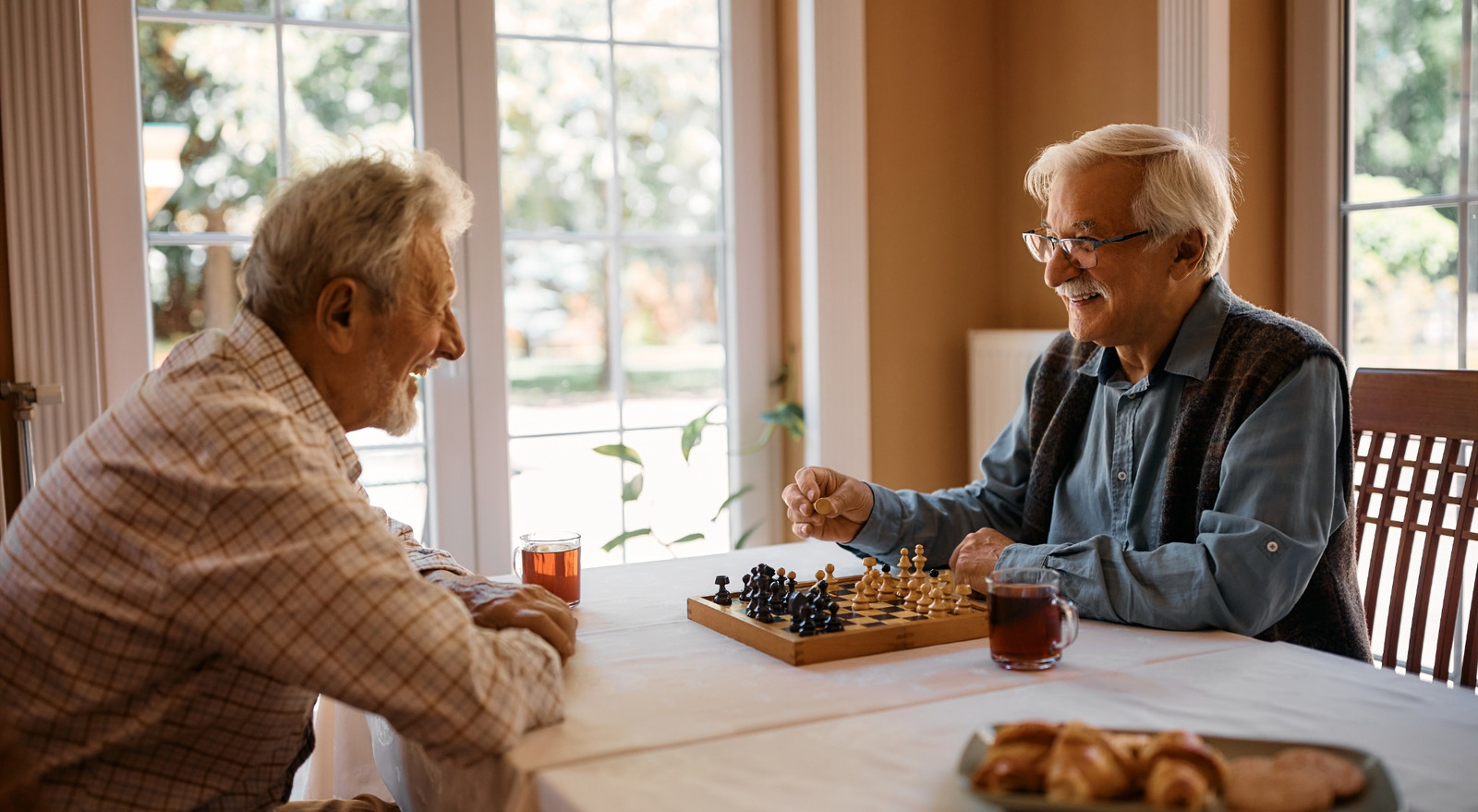 Two men playing chess at home.