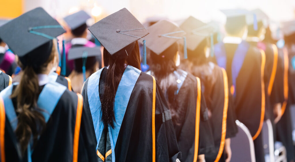 University students graduating wearing caps and gowns.