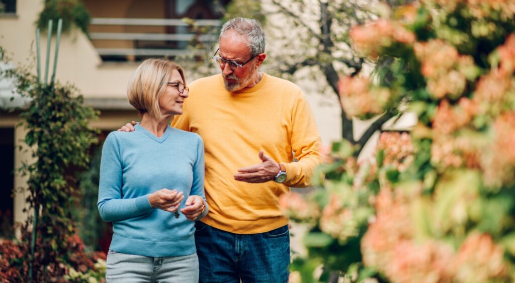 Mature couple walking outside a house