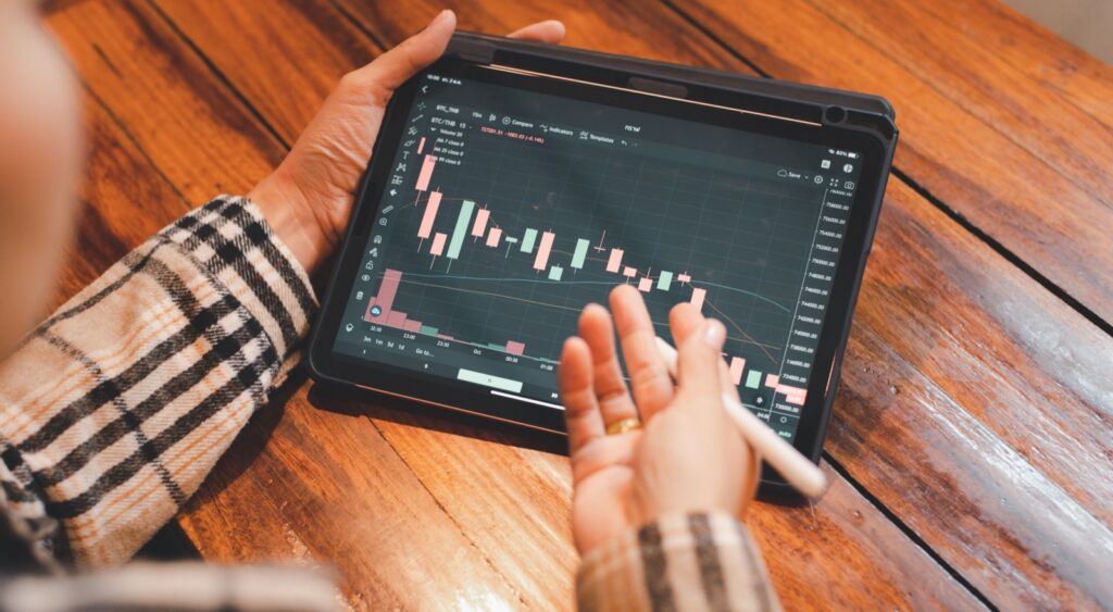 A person looking at investment performance on a tablet.