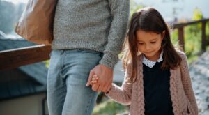 A mother and daughter holding hands.